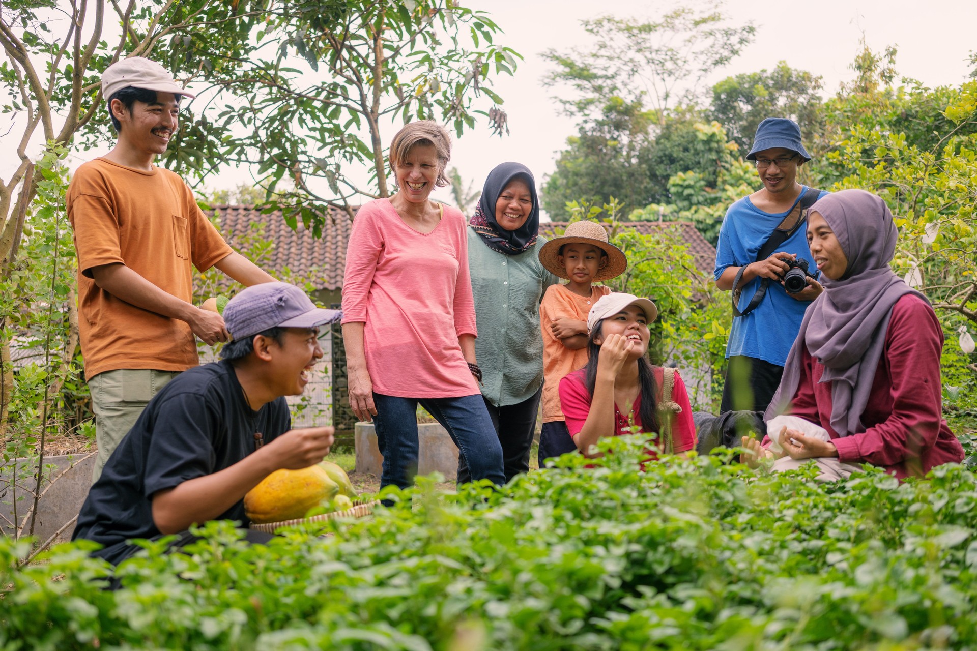 Muslim Woman Teaching Group of Diverse Visitor Trying Tasting Wild Edible Plants In a Garden